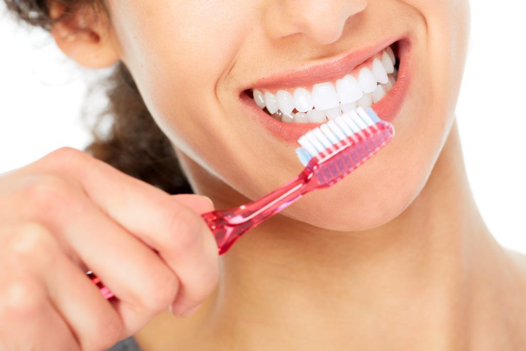 Close up of a woman's mouth with a toothbrush about to brush the teeth